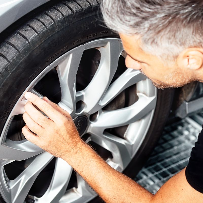 Ein Unfall Spezialist repariert die Felgen bei einem Fahrzeug.