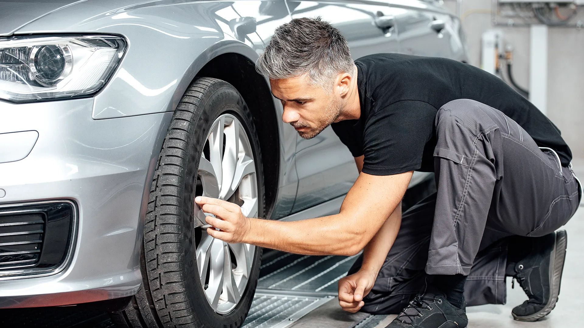 Ein Unfall Spezialist repariert die Felgen bei einem Fahrzeug.