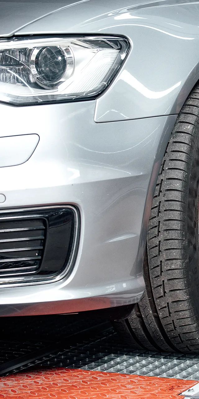 Ein Unfall Spezialist repariert die Felgen bei einem Fahrzeug.